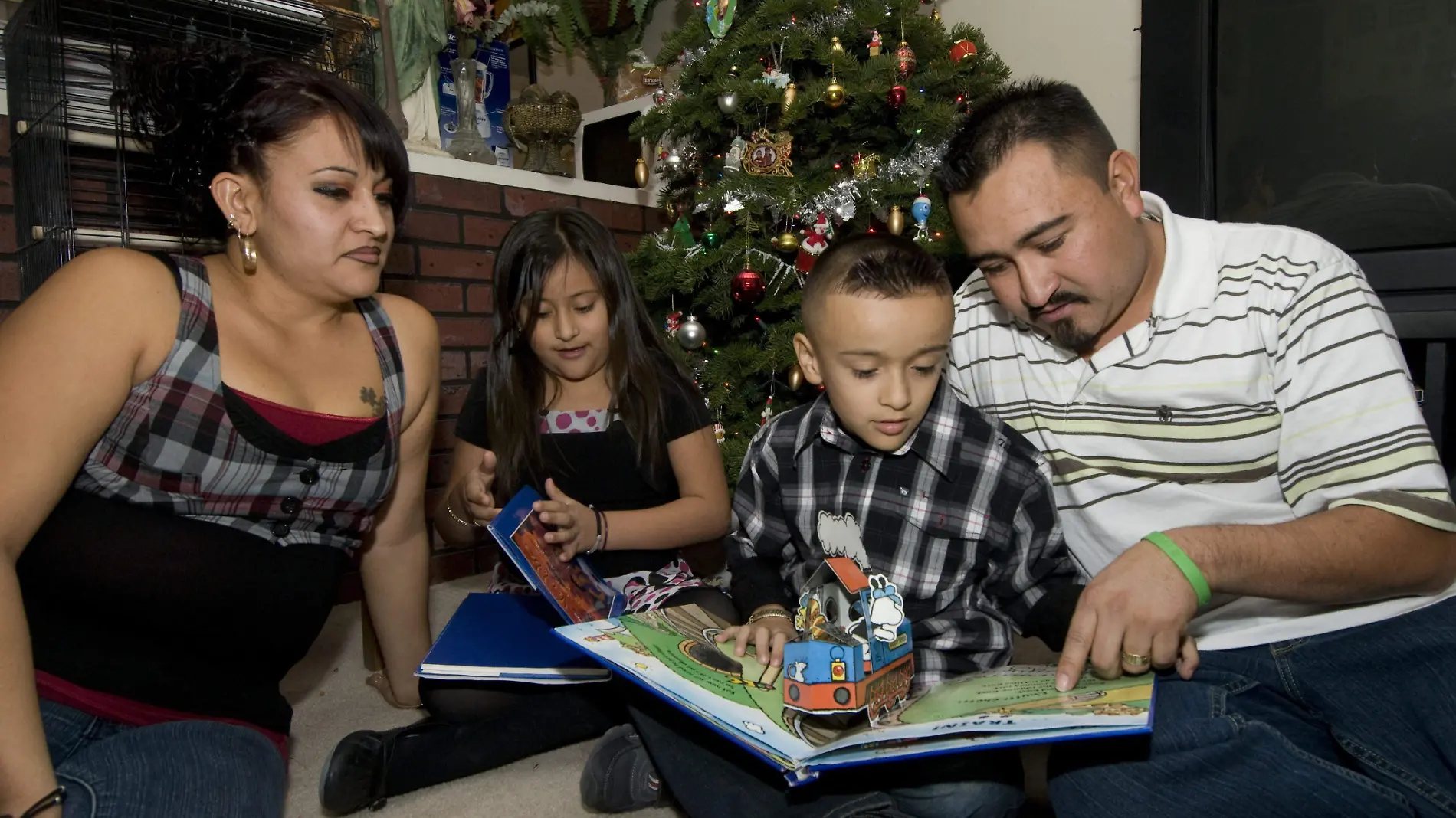 El mexicano Roberto Franco Batierra posa junto a su familia frente al árbol de Navidad de su casa en Tucson (Arizona, EEUU) y refleja el sentimiento de unidad que se está perdiendo por el consumismo que impera